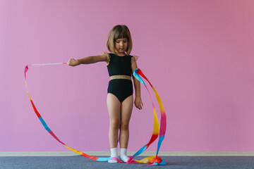 Aesthetics of gymnastics. Pink, black and gold colors. Rainbow ribbon