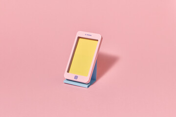 Craft smartphone handmade from color paper on a stand.