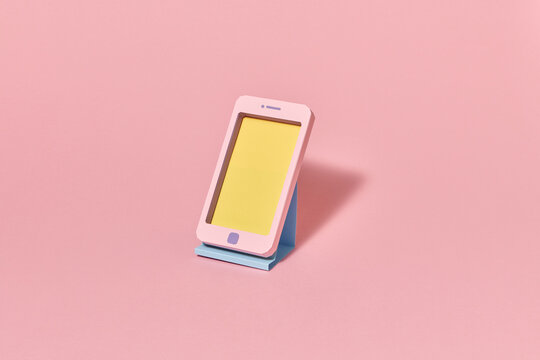 Craft smartphone handmade from color paper on a stand.