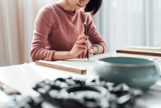 Asian woman writing calligraphy