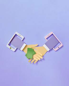 Smartphones with papercraft hands greeting each other.