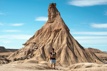 young boy with backpack and short jeans traveling in the desert landscape of Bardenas Reales, Navarra © marina