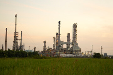 Oil refinery plant chemical factory and power plant with many storage tanks and pipelines at sunset.