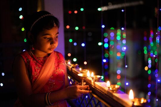 Little Girl Igniting Oil Lamps During Diwali