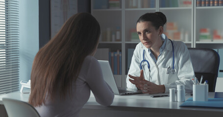 Caring doctor assisting a young patient in the office