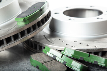 brake pads and perforated brake discs on a stone gray table