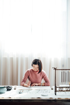 Asian woman writing calligraphy