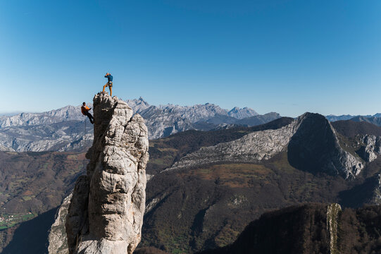 Climbing guide rappelling from top of pinnacle