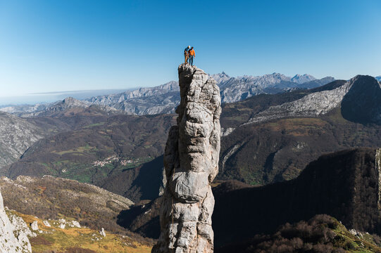 Climbing partners on top of distant pinnacle