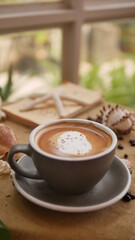 A cup of cappuccino with shell-shaped and coffee bean background.