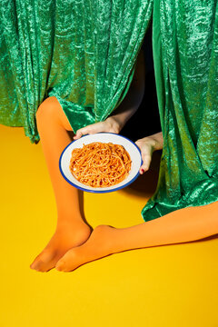Woman holding spaghetti on studioWoman with red nails and oran