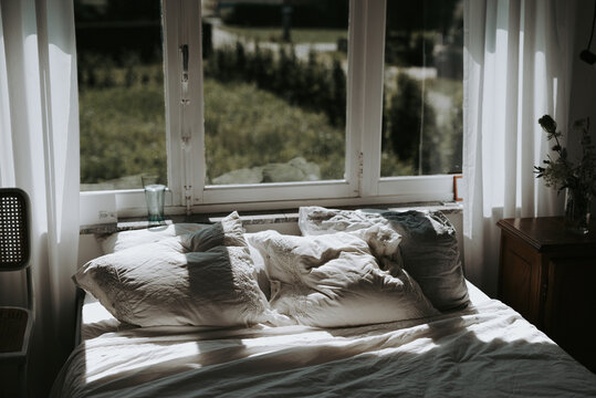 romantic but messy bed with morning light