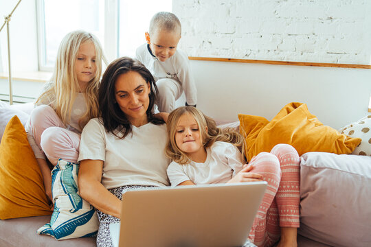 mom and her adorable kids spend time watching movies at home
