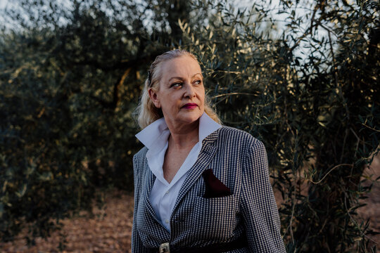 Senior woman looking to the side at olive grove with flamenco attitude
