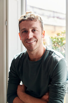 Smiling designer standing by an office window