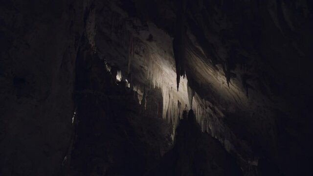 Dark underground cave with stalactites.