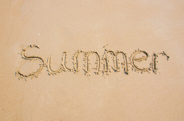 Word " summer " written on sand