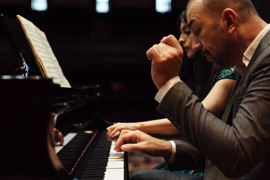 Man and woman, playing a piano