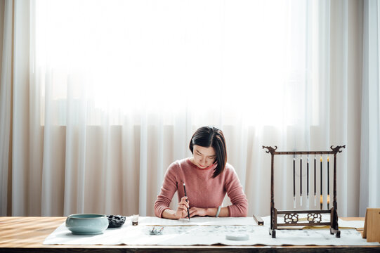 Asian woman writing calligraphy