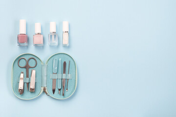 Manicure or pedicure set equipment with nail coat or polish, on blue background, horizontal, copy...