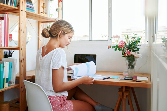 College student reading a textbook in her room