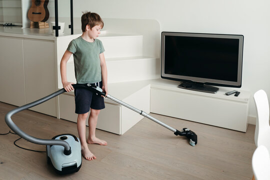 A young boy is cleaning the room.