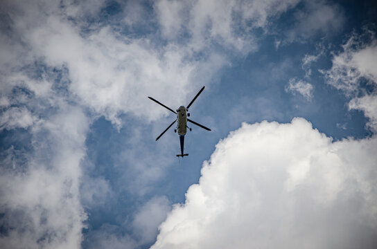 
helicopter in the blue sky with clouds
