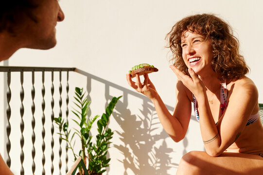 Young couple sitting on their sunny balcony