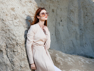 Beautiful woman in light clothes near the rocks in nature