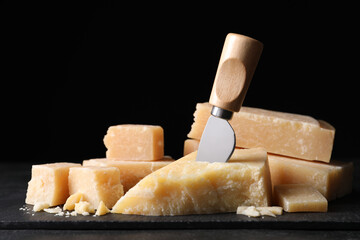 Fototapeta premium Parmesan cheese with slate plate and knife on table, closeup