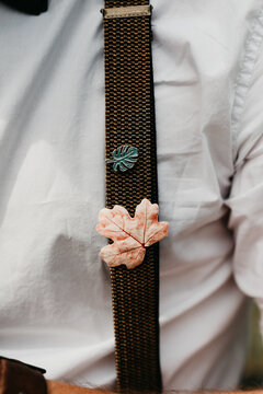 close up of male with suspenders and 2 brooches