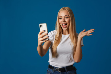 Excited woman holding copyspace while taking selfie on cellphone