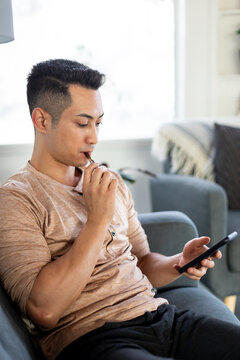 Man Smokes Using Weed Pen and Scrolls On His Phone