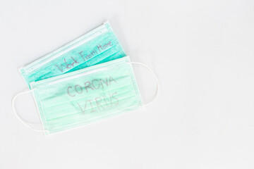 Writing Corona Virus on green medical mouth mask, face mask protection against pollution, virus, flu. Health care and medical concept on white background.