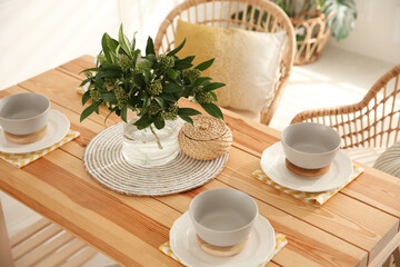 Stylish wooden dining table and chairs in room. Interior design