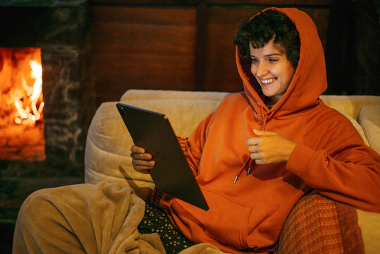 Woman with iPad near fire place.