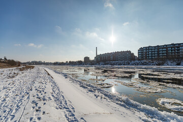 
wide-angle view of the winter city by the river with blue sky