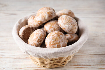 Tasty homemade gingerbread cookies in basket on white wooden table