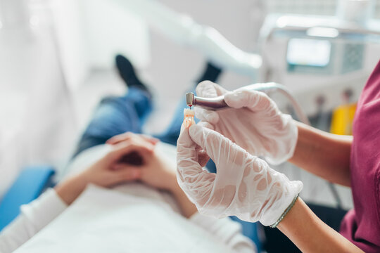 A Dentist Fixing an Artificial Tooth