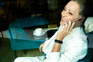 Senior business having fun calling by phone at coffee shop