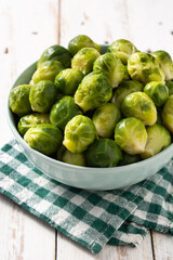 Set of brussel sprouts in a bowl on white wooden table