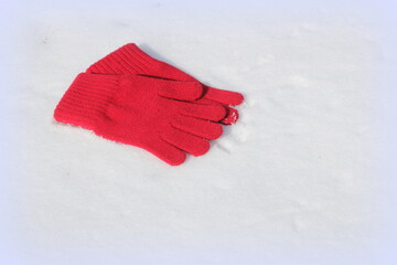 Red gloves on white snow background