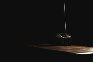 Transistor radio on the table in black backdrop.