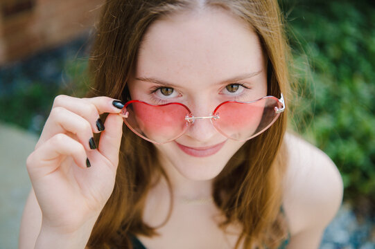 face of teen girl in heart shaped sunglasses