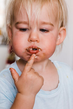 Little Girl Stuffing Mouth Full Of Birthday Cake