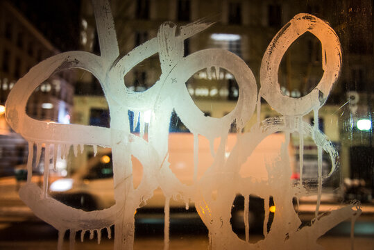 Snowy and frozen reflections of Paris at nigh seen through a phone cabine