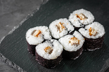 appetizing sushi roll maki with eel and unagi on a black stone plate