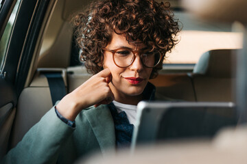 A Woman in the Car Using a Digital Tablet