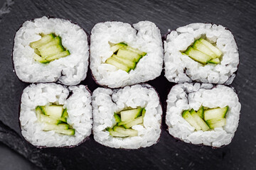 appetizing sushi roll maki with cucumber on a black stone plate © Narsil