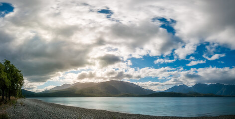 Lake Te Anau Panorama with sun rays filtered through the clouds at Te Anau in Fiordland National Park in New Zealand, South Island.
